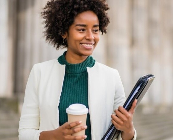 black lady holding coffee and files